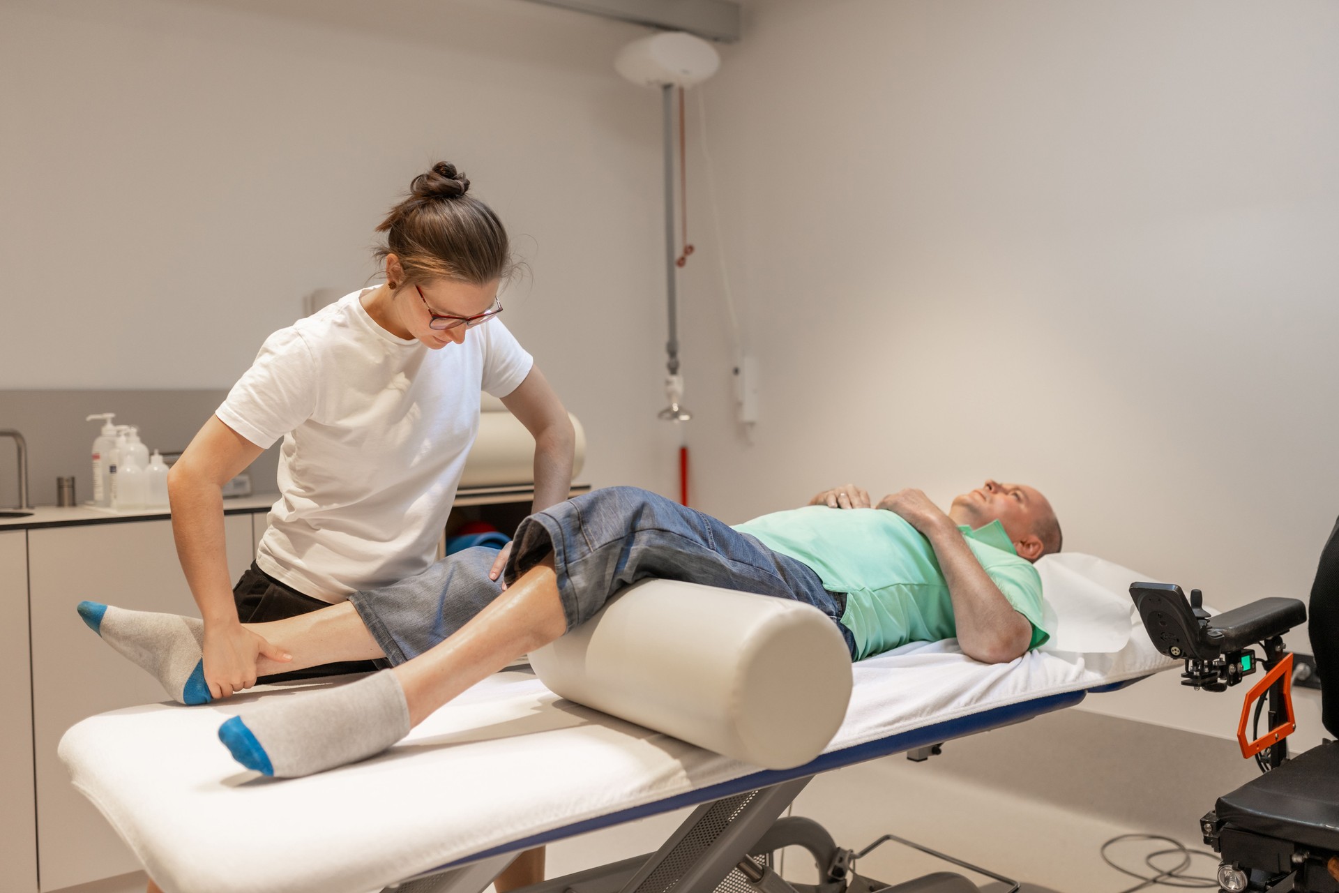 A disabled person with a physiotherapist at a physiatry rehabilitation office