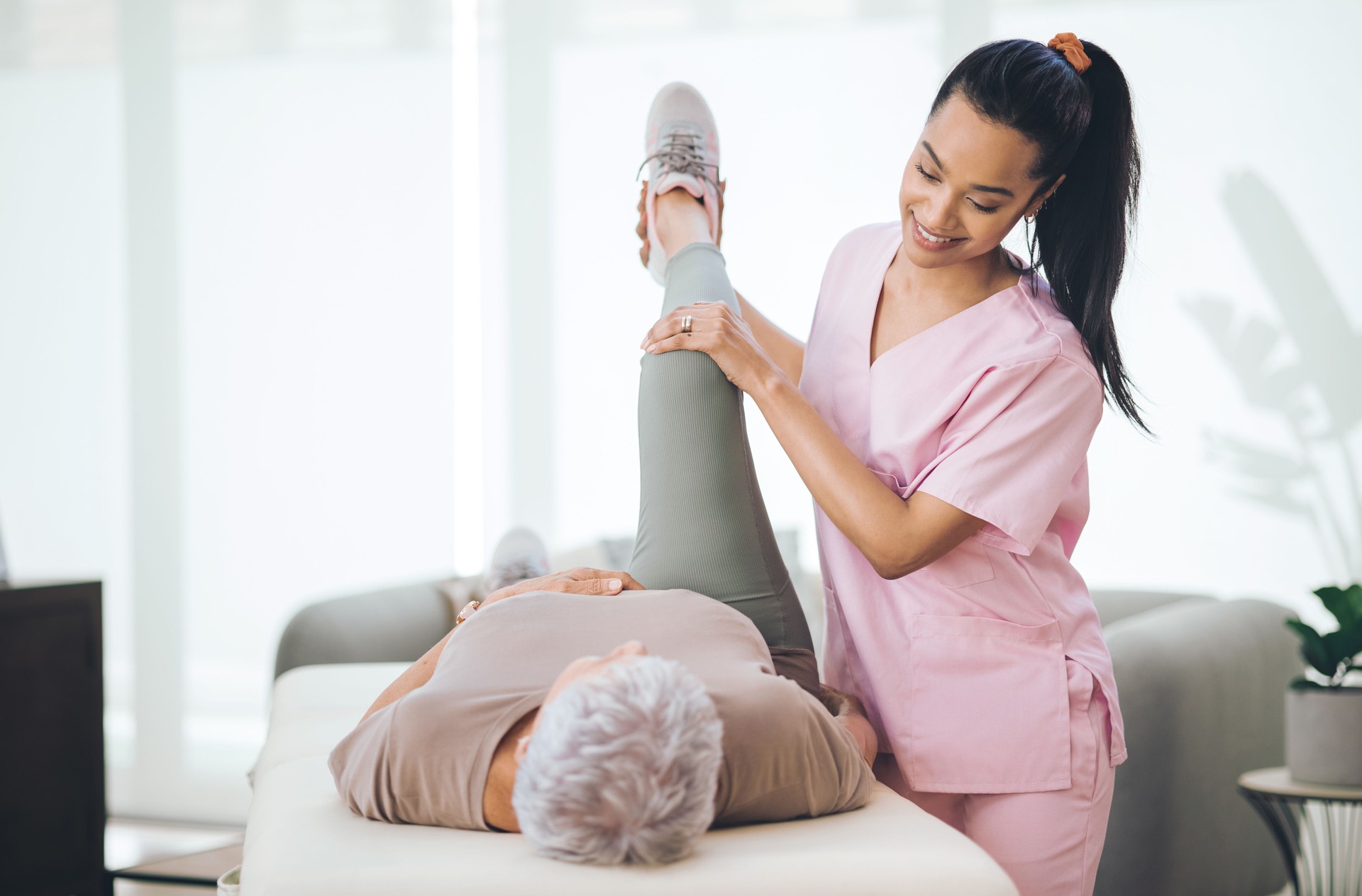 Shot of an older woman doing light exercises during a session with a physiotherapist inside